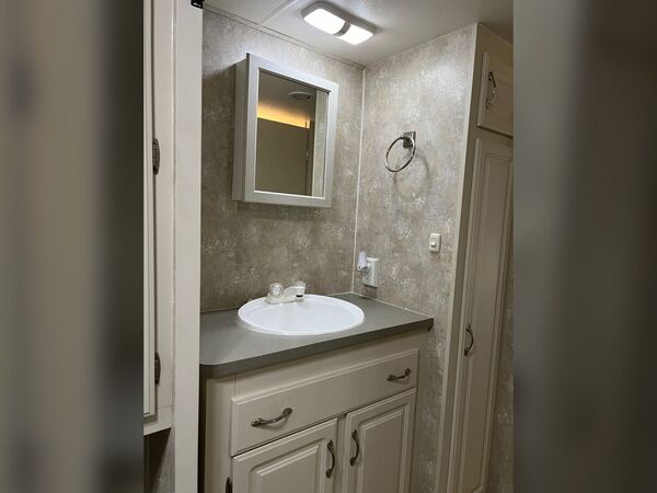 Bathroom vanity with a sink, white cabinet and a mirrored medicine cabinet
