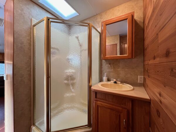 Bathroom with a corner glass shower, a vanity sink and a mirrored medicine cabinet